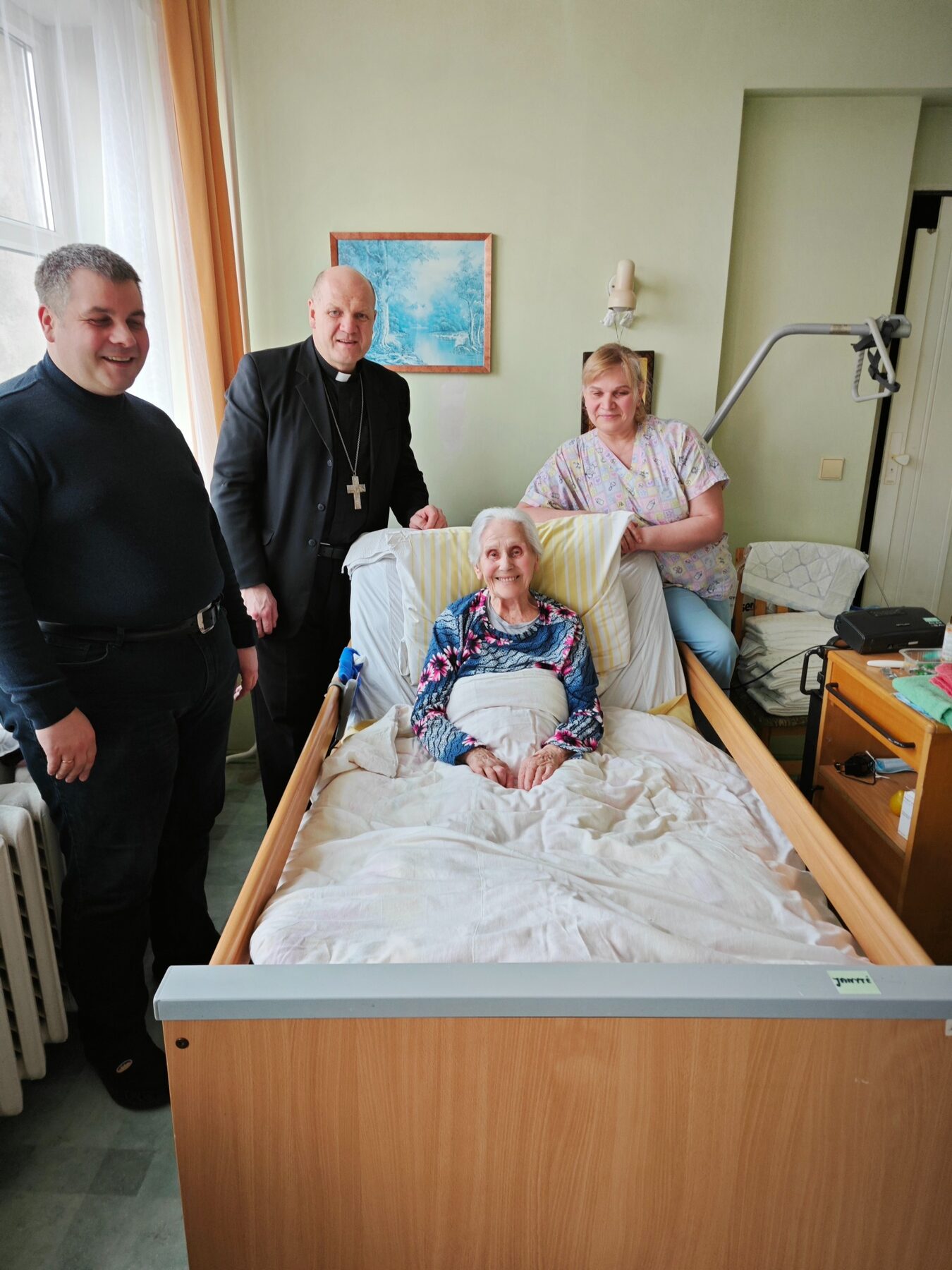 Dvasininkas ir darbuotojai lanko gyventoją