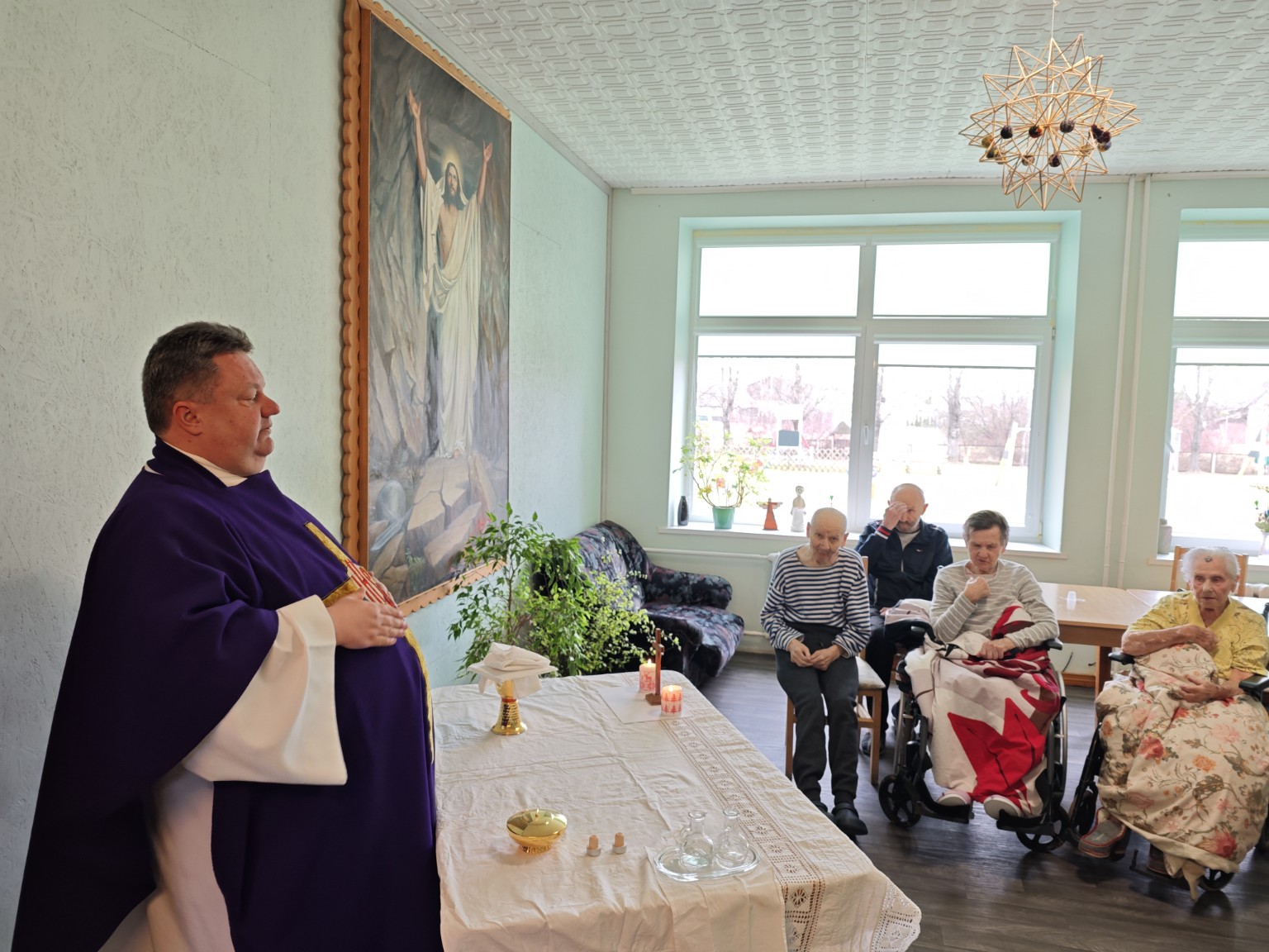 Kunigas aukoja šv. Mišias globos namų gyventojams